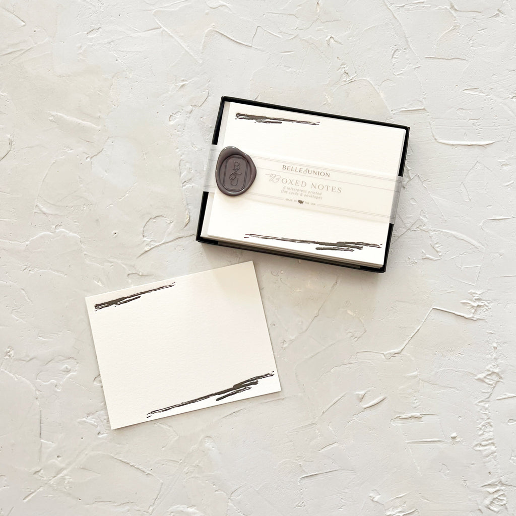 Ivory note cards with image of black brushstrokes in top left corner and bottom right corner.