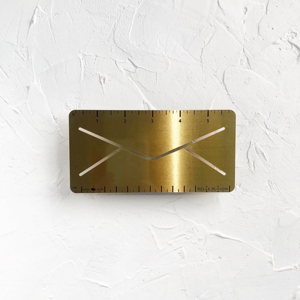 Small 6” brass ruler in the shape of an envelope.