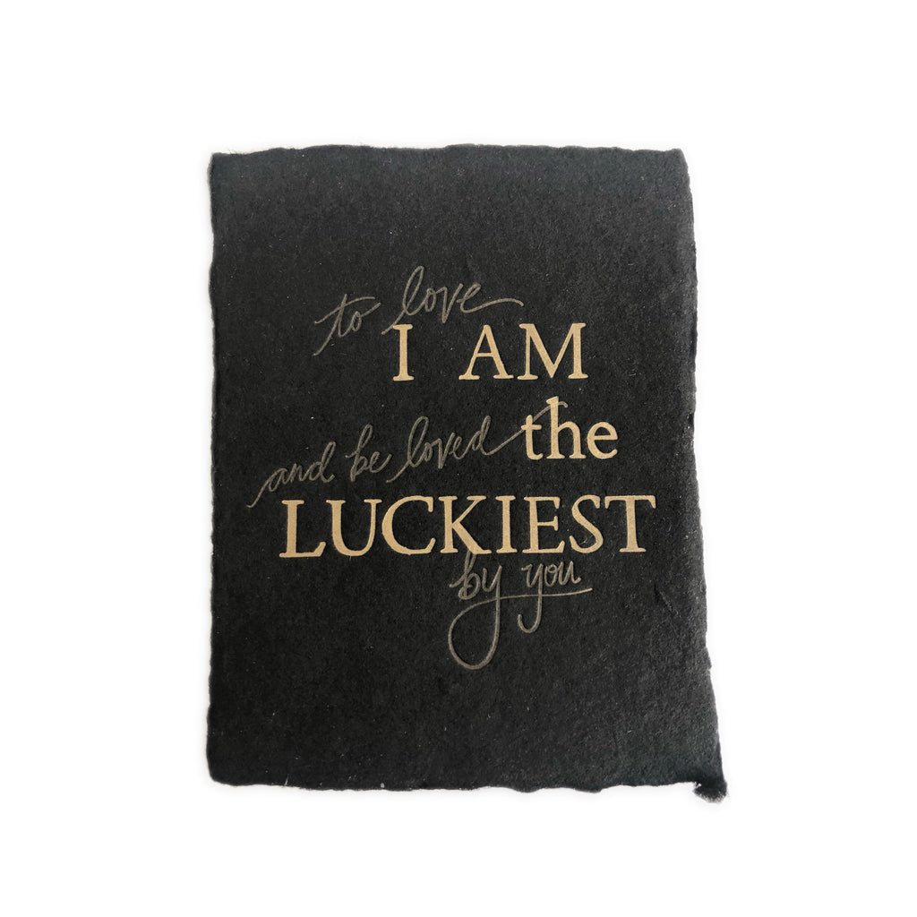 Black card with torn edges and gold foil text saying,