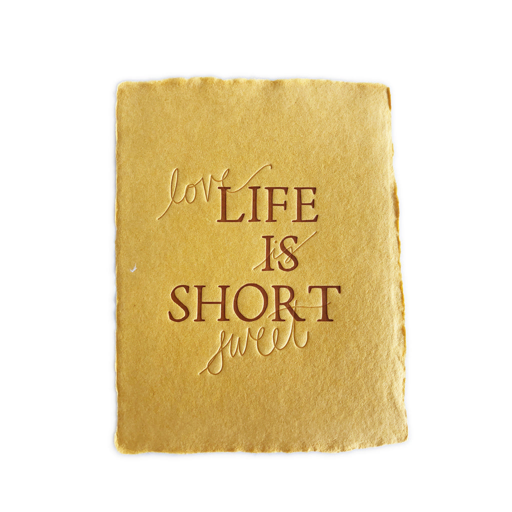 Mustard yellow card with brown and embossed text saying,