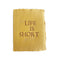Mustard yellow card with brown and embossed text saying,