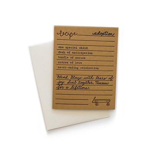 Brown card with black and brown text saying, “Recipe for Adoption: One special child; dash of anticipation; bundle of nerves; scores of love; never-ending celebration; Blend, Glaze with tears of joy. Seal Together. Treasure for a Lifetime.” Image of a child’s wagon in bottom right corner. A white envelope is included.