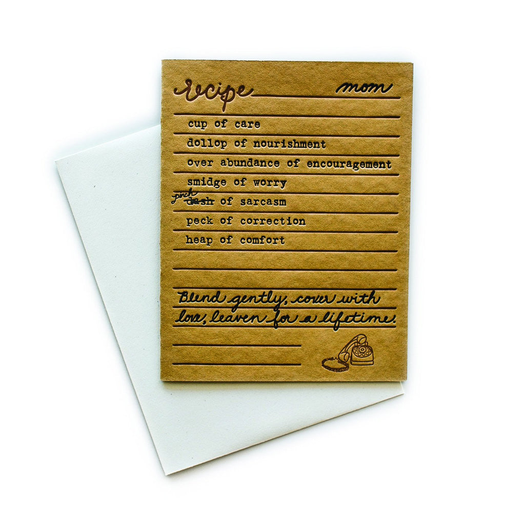 Brown card with black and brown text saying, “Recipe for Mom: cup of care; dollop of nourishment; over abundance of encouragement; smidge of worry; pinch of sarcasm; peck of correction; heap of comfort. Blend gently, cover with love, leaven for a lifetime.” Image a box of a rotary telephone in bottom right corner. A white envelope is included.