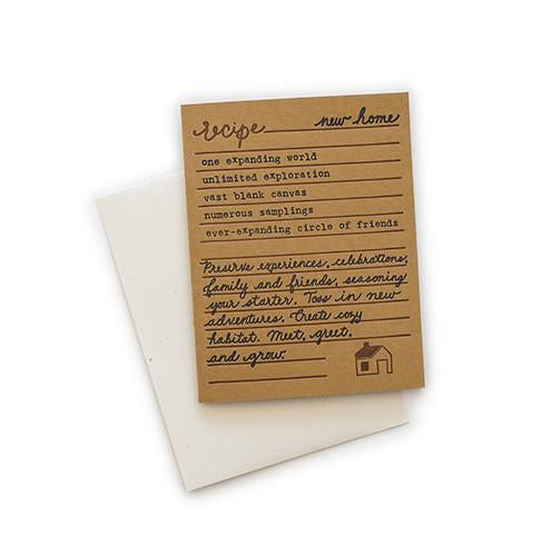 Brown card with black and brown text saying, “Recipe for New Home: one expanding world; unlimited exploration; vast blank canvas; numerous samplings; ever-expanding circle of friends. Preserve experiences, celebrations, family and friends, seasoning your starter. Toss in new adventures. Create cozy habitat. Meet, greet, and grow.” Image of house in bottom right corner. A white envelope is included.