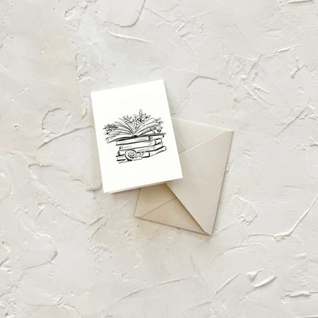 Black and white card with image of an envelope with greenery coming out of top open book. Snail in front of pile. A tan envelope is included.