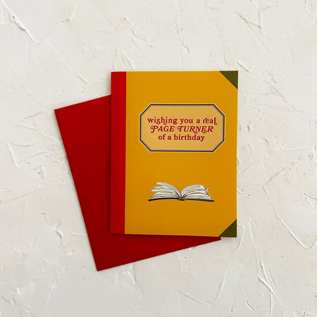 Yellow birthday card with red envelope on a textured white background