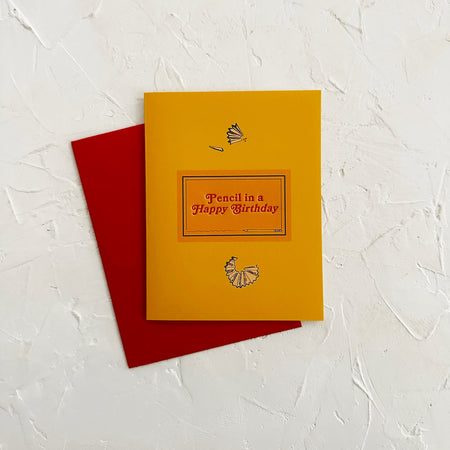 Yellow birthday card with red envelope on a textured white background